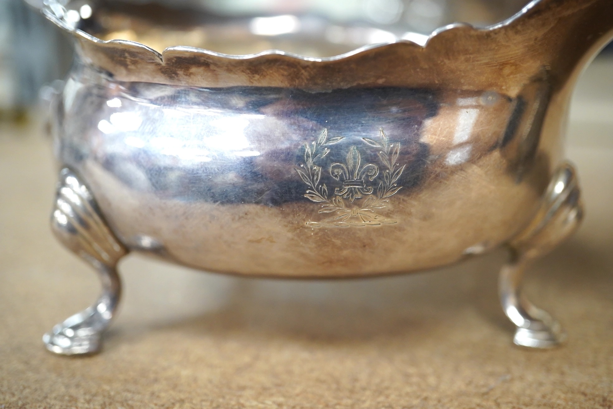 A George II silver sauce boat, London, 1746?, (repair), together with a George V silver sauceboat by Elkington & Co, Birmingham, 1914, 10.5oz. Condition - poor to fair